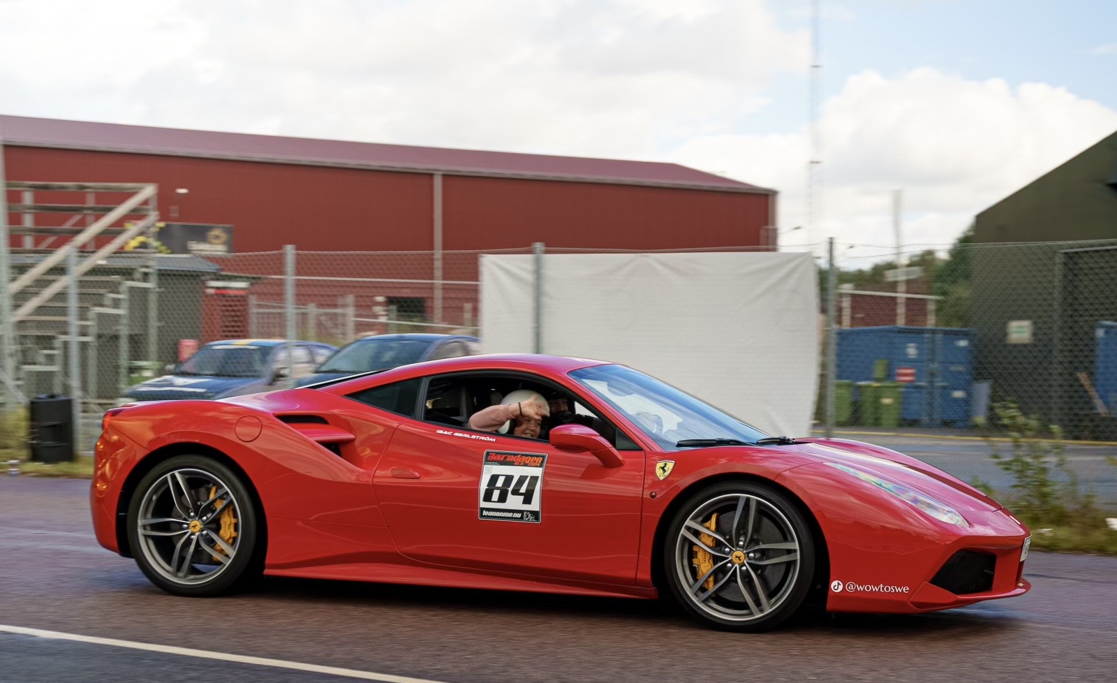 En Rosso Corsa Röd Ferrari 488 V8 DCT som kör på en motorbana.