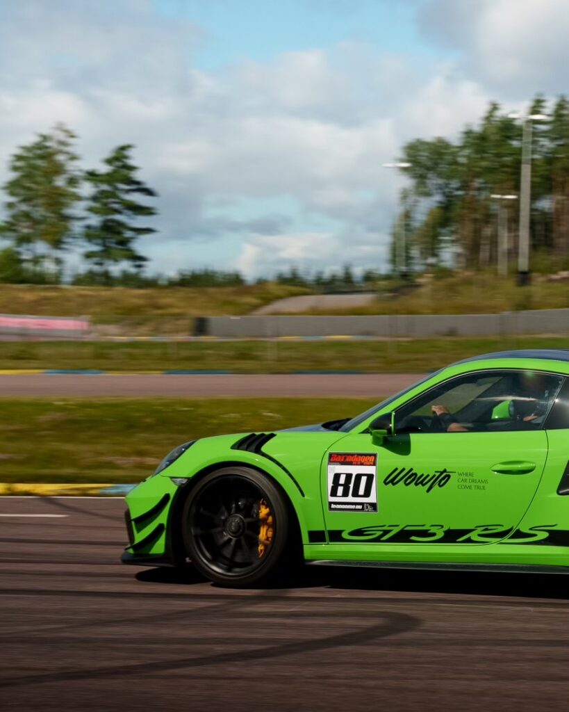 En lizard green Porsche 911 991.2 GT3 RS PDK / Weissach kör på en racerbana.